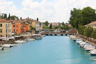 Peschiera del garda colorful and flowered harbor with boats moored lake garda, italy