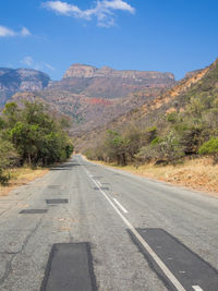 Road by mountain against sky