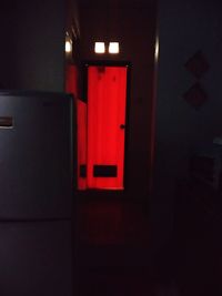 Red illuminated light on wall in building