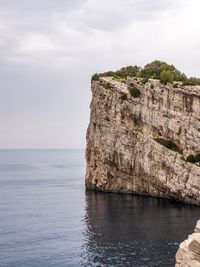 Rock formations by sea against sky