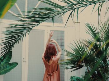 Rear view of woman standing by plants