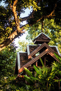 Low angle view of trees and building against sky