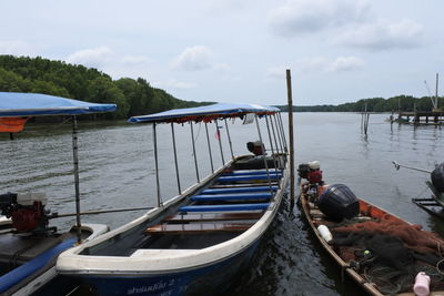 Boats moored in lake against sky