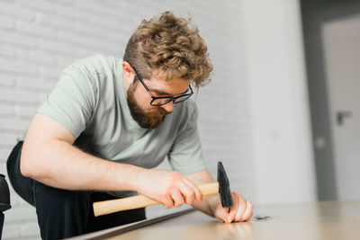 Side view of young man working at home