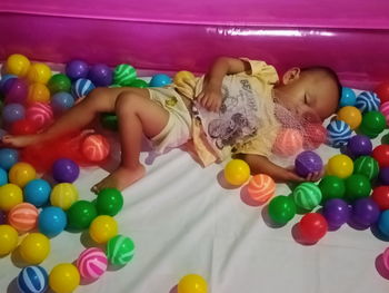 High angle view of boy playing with toy in bed