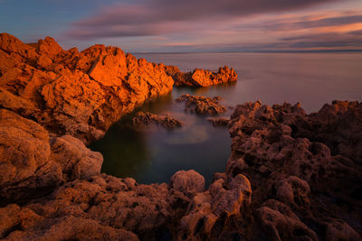 High angle view of rocky coastal feature against sky