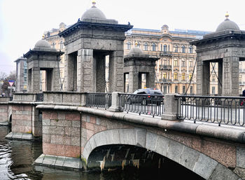 Arch bridge over canal against buildings in city