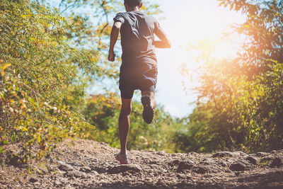 Rear view of man running on plants