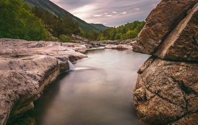 Scenic view of river amidst rocks against sky