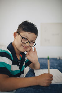 Portrait of boy studying at table in home