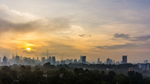 Scenic view of city against sky during sunset