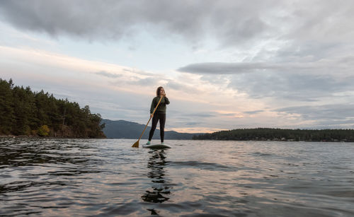 Full length of man standing in water against sky