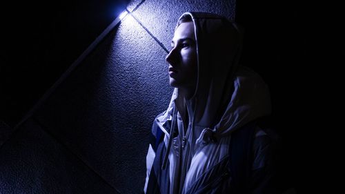 Woman wearing hood in darkroom