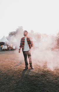 Full length of young man standing against clear sky