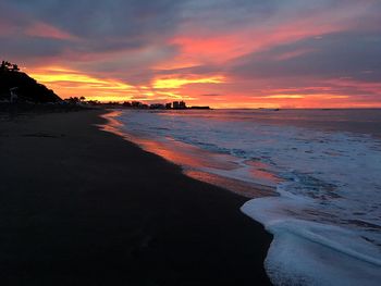 Scenic view of beach against dramatic sky