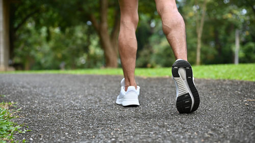 Low section of man jogging on road