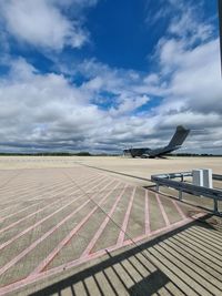 View of airport runway against cloudy sky