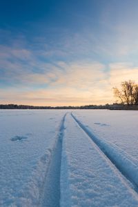 Scenic view of snow covered field against sky during sunset