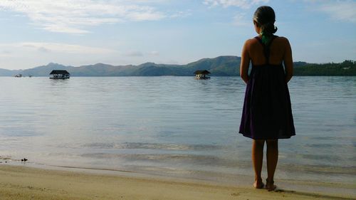Rear view of woman standing on beach
