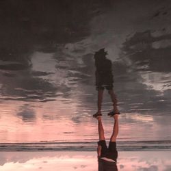 Man standing on beach against sky during sunset