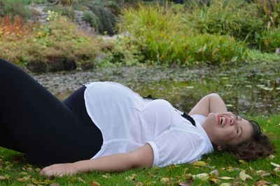 Woman looking at camera while sitting in park