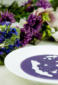 Close-up of soup served in bowl with flowers on table