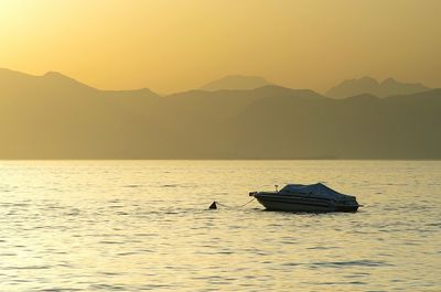 Silhouette boat in sea against clear sky during sunset