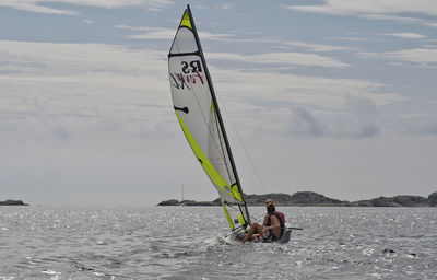 People windsurfing on sea against sky