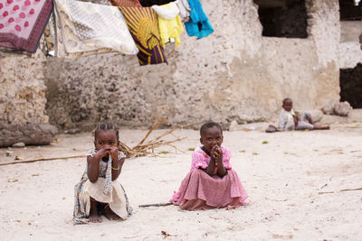 Rear view of children playing with umbrella