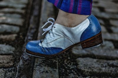 Low section of woman standing on footpath