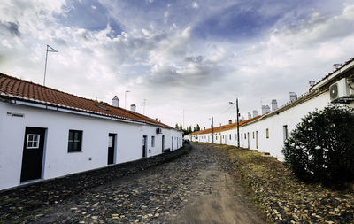 Road amidst buildings against sky