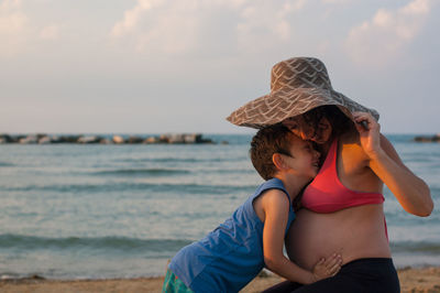 Woman wearing hat at beach against sky