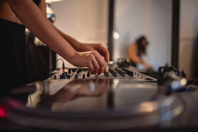 Midsection of woman playing sound mixer at home