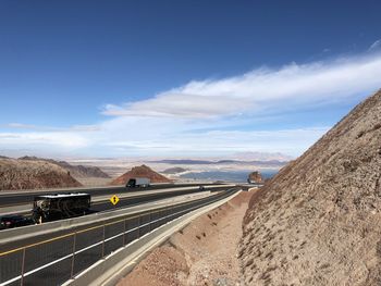 Road leading towards mountains against blue sky