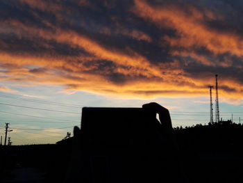 Silhouette of built structure against cloudy sky