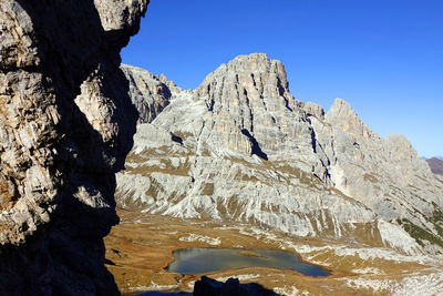 Low angle view of rock formations against clear blue sky