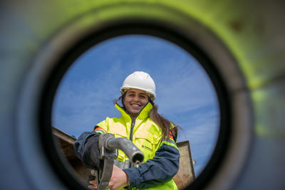 Portrait of young woman through fuel reservoir 