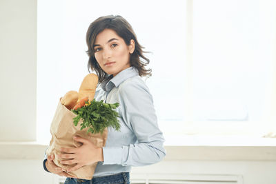 Portrait of beautiful woman standing against wall