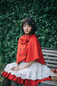 Young woman holding apple and sitting on bench