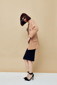 Portrait of young woman standing against white background