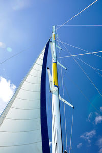 Low angle view of sailboat against blue sky