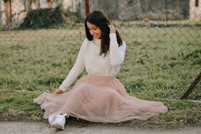 Full length of beautiful young woman lying on land, long princess pink skirt