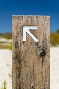 Close-up of sign on wooden post