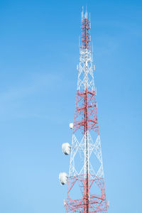 Low angle view of communications tower against clear blue sky