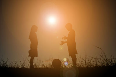 Silhouette people playing at sunset