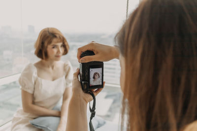 Portrait of woman photographing with mobile phone