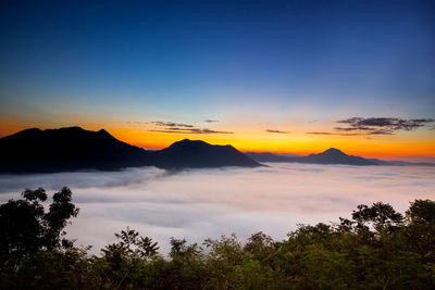 Scenic view of cloudscape and mountains against sky during sunset