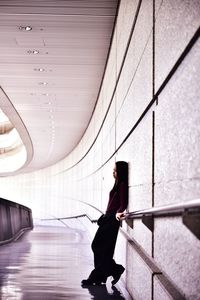 Side view of woman walking in corridor