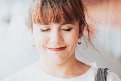 Close-up of young woman smiling with eyes closed