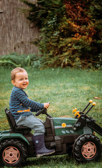 Boy sitting on toy car